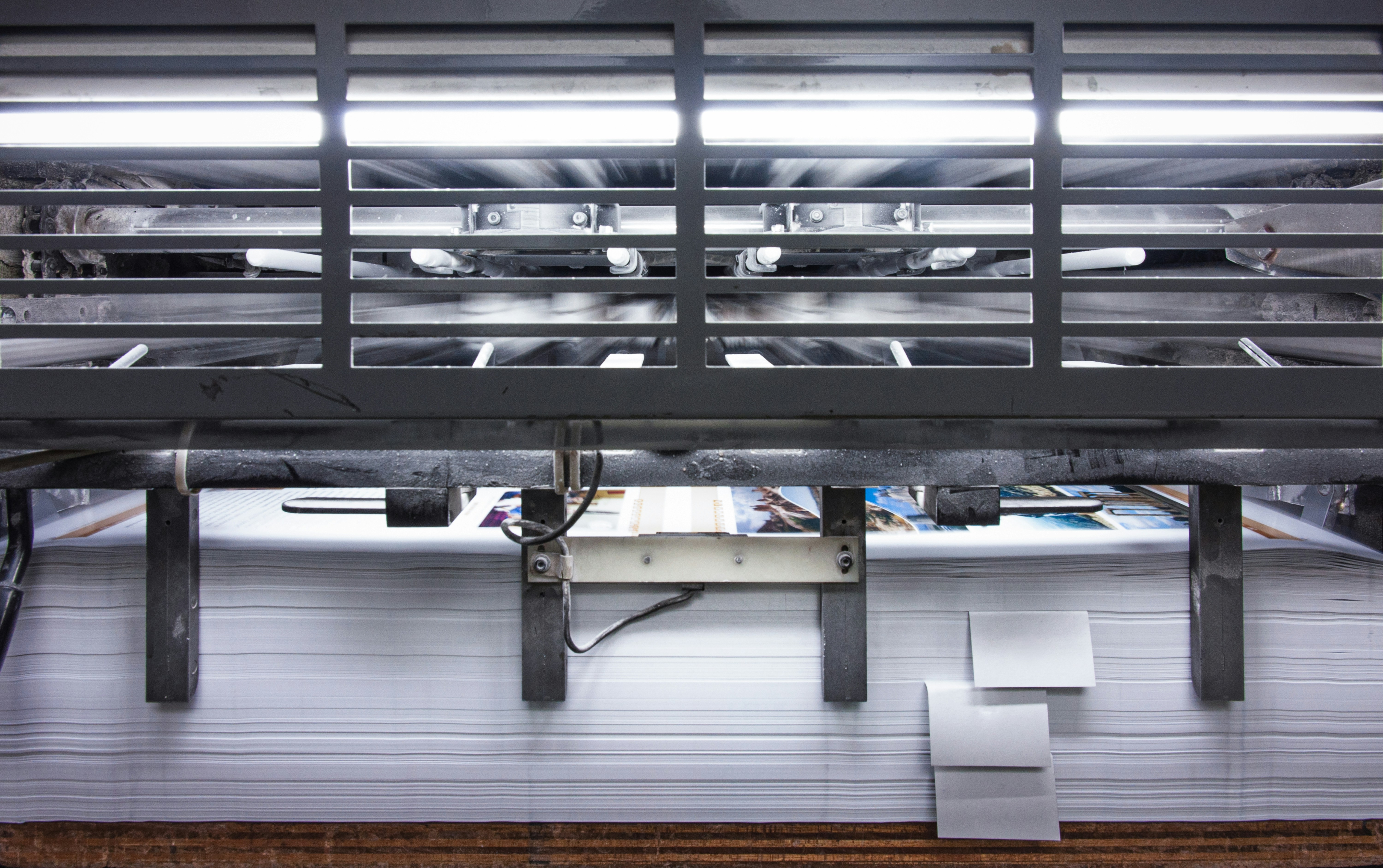 Printed pages moving through a publishing press
